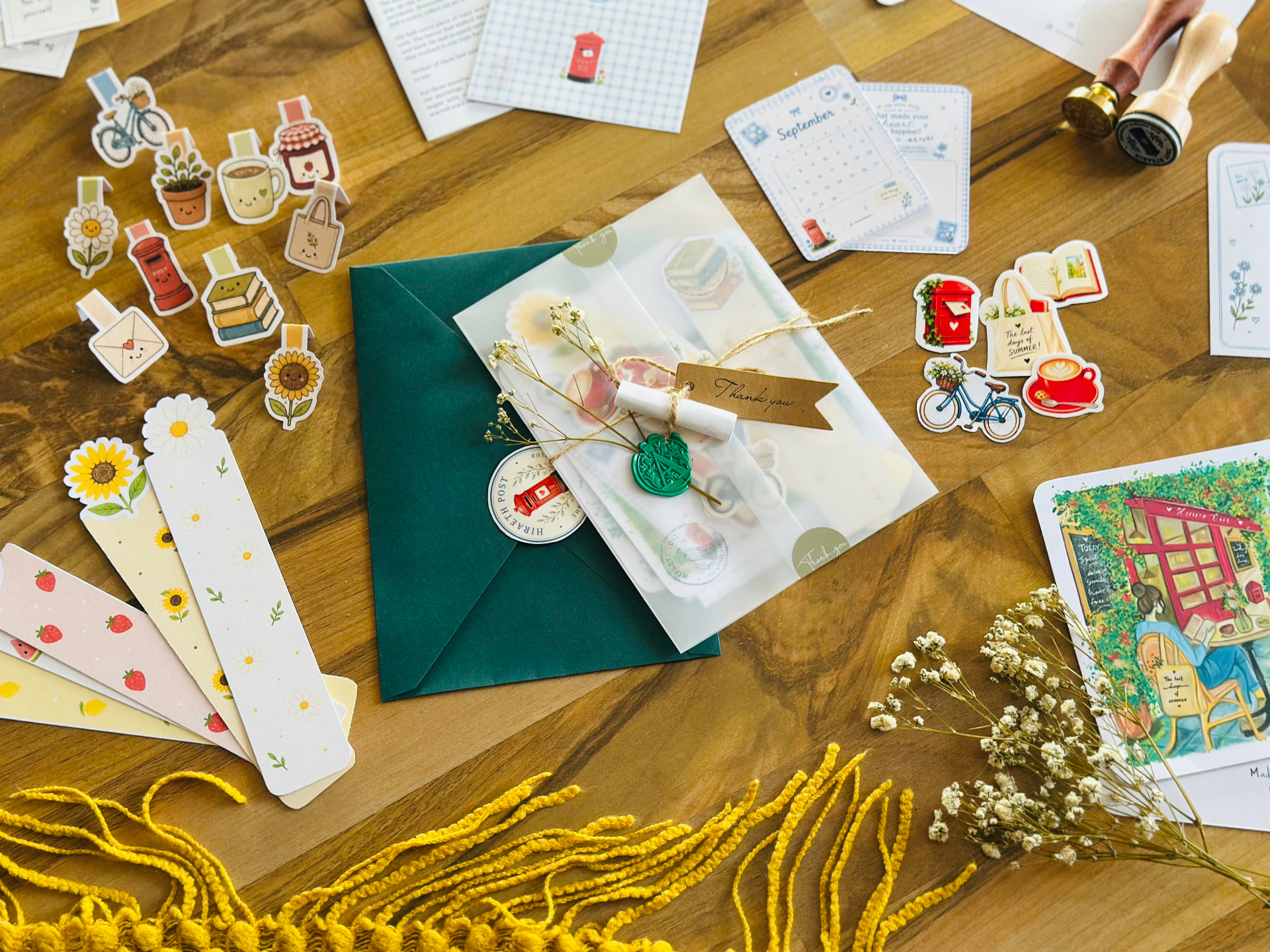 Hands arranging letters, sketches and postcards on a wooden desk